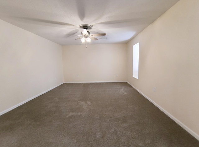 unfurnished room featuring ceiling fan and dark colored carpet