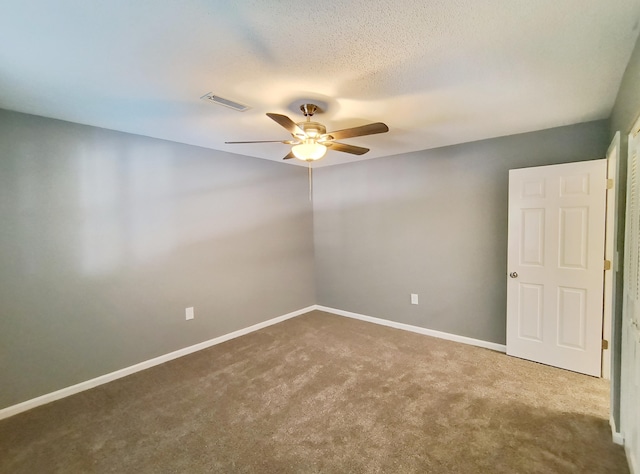 spare room featuring ceiling fan, carpet floors, and a textured ceiling