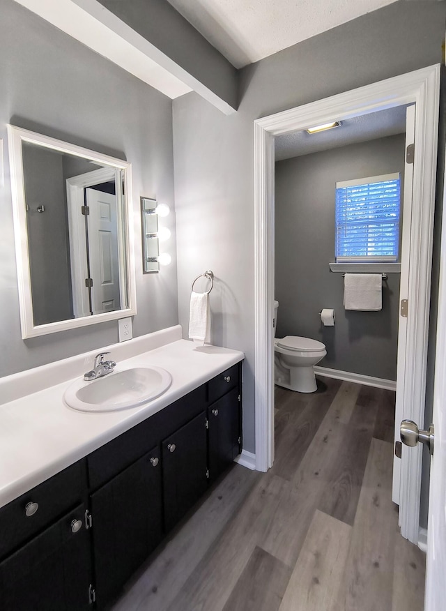 bathroom with vanity, hardwood / wood-style flooring, a textured ceiling, and toilet