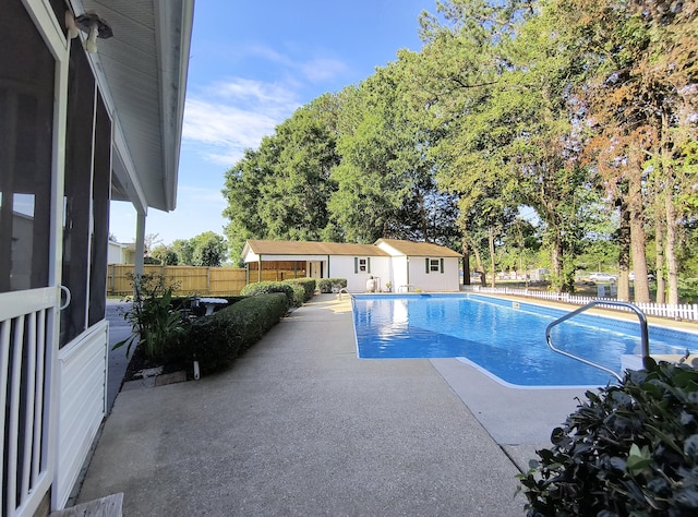 view of pool with an outbuilding and a patio