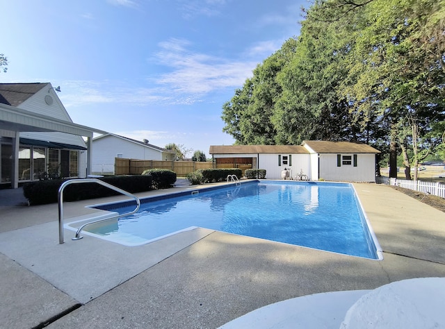 view of pool with a patio and an outbuilding