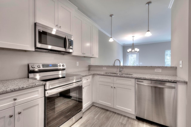 kitchen with appliances with stainless steel finishes, sink, a chandelier, light stone counters, and white cabinets