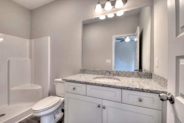 bathroom featuring vanity, toilet, walk in shower, and ceiling fan