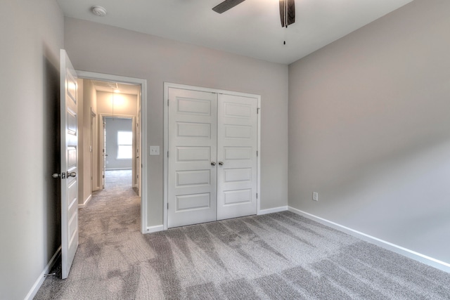 unfurnished bedroom with light colored carpet, ceiling fan, and a closet