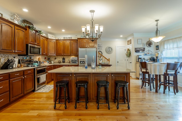 kitchen with light wood-type flooring, appliances with stainless steel finishes, and a center island with sink