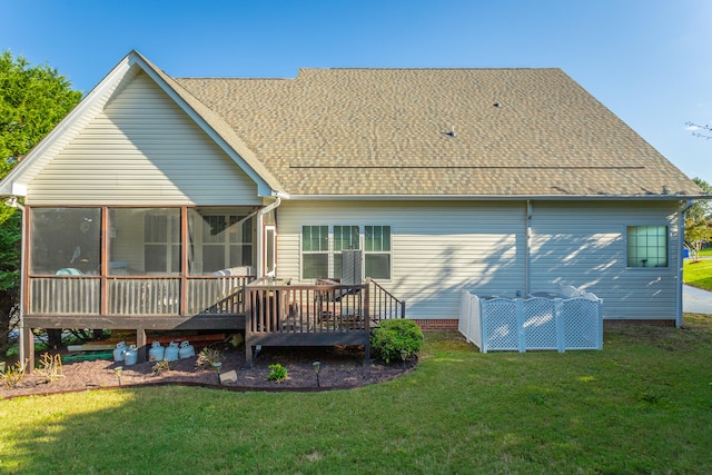 rear view of property featuring a yard, a wooden deck, and a sunroom