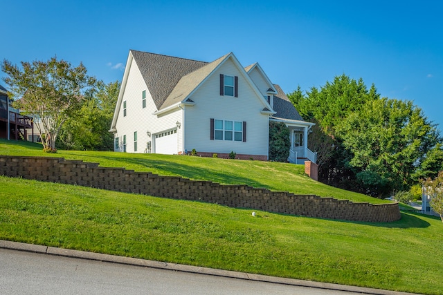 view of home's exterior with a garage and a lawn