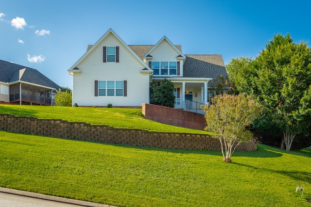 view of front of home featuring a sunroom and a front yard