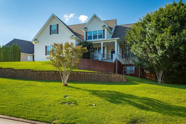 back of house with a lawn and covered porch