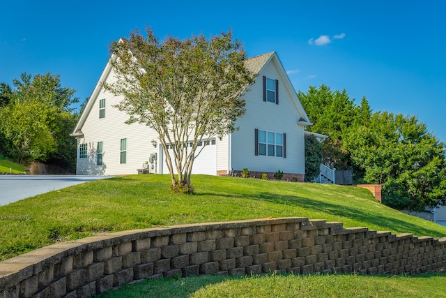 view of side of property with a garage and a lawn