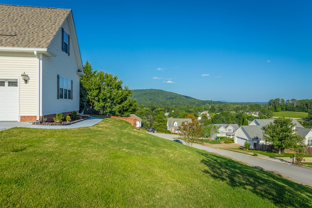 view of yard with a garage and a mountain view