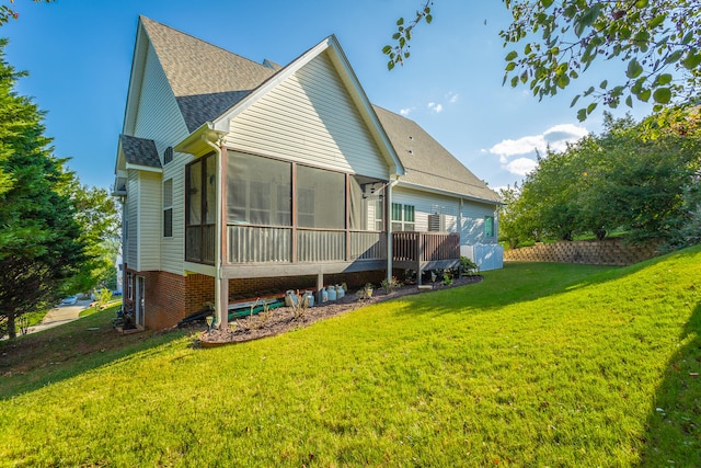 back of house featuring a yard and a sunroom