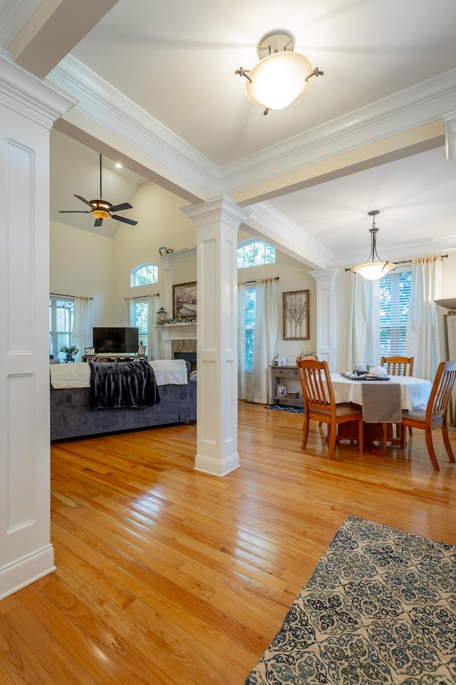 living room with decorative columns, ceiling fan, lofted ceiling, and light hardwood / wood-style floors