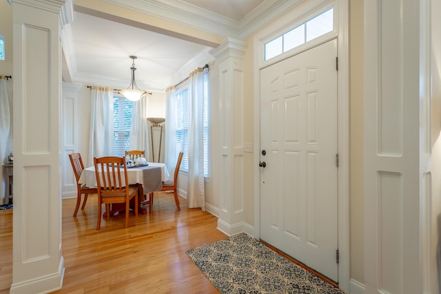 entrance foyer with a healthy amount of sunlight, decorative columns, and light hardwood / wood-style floors