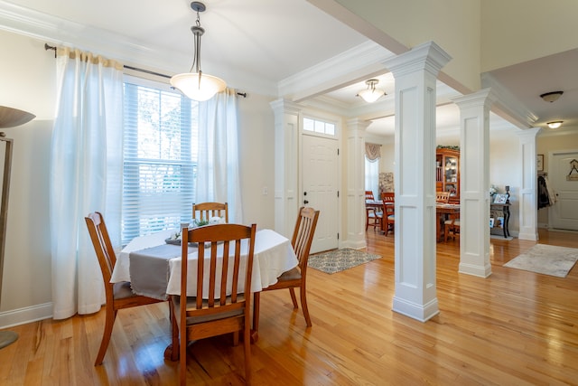 dining space with ornamental molding, decorative columns, and light hardwood / wood-style floors