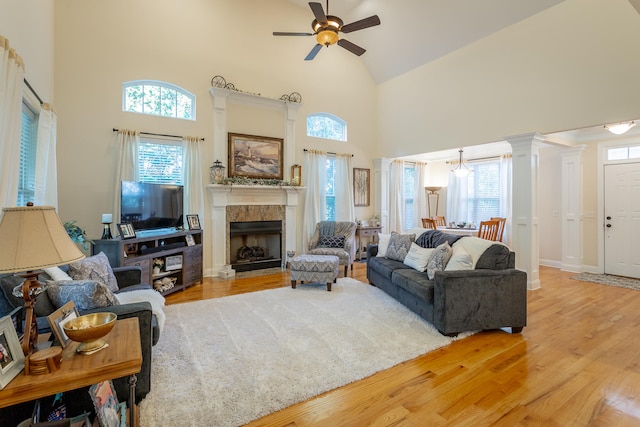 living room with high vaulted ceiling, ornate columns, ceiling fan, and light hardwood / wood-style flooring