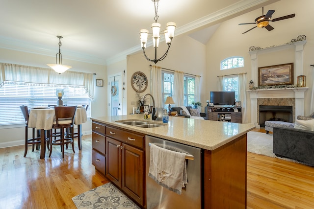 kitchen with ceiling fan with notable chandelier, dishwasher, light hardwood / wood-style floors, sink, and light stone counters