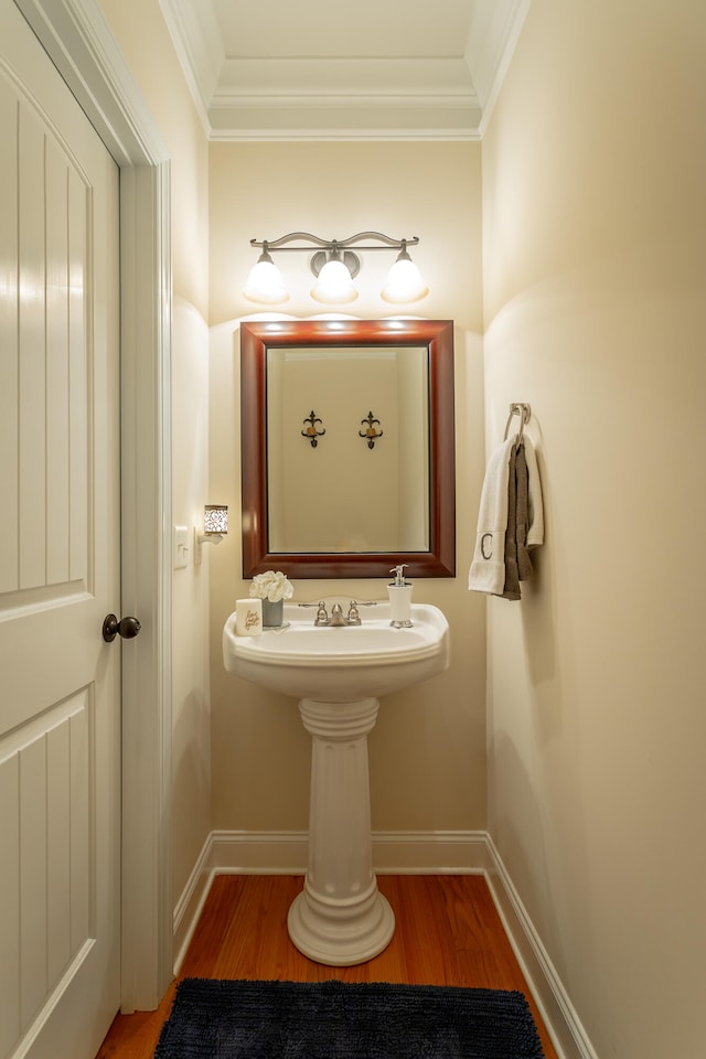 bathroom with wood-type flooring and crown molding