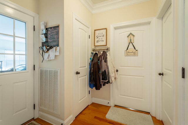 doorway with crown molding and light hardwood / wood-style floors