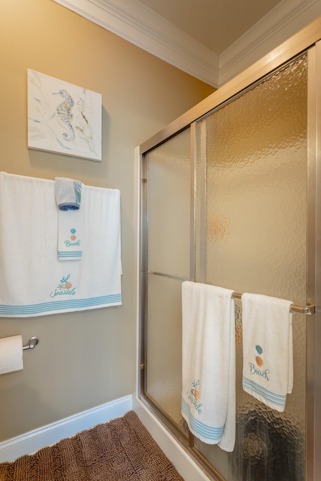 bathroom with crown molding and an enclosed shower