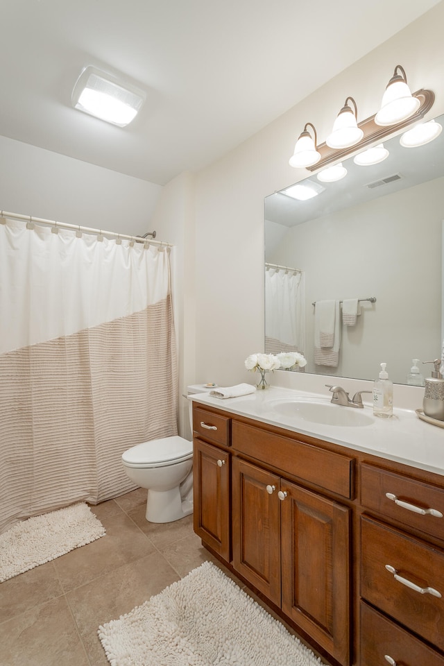 bathroom featuring tile patterned floors, a shower with curtain, toilet, and vanity