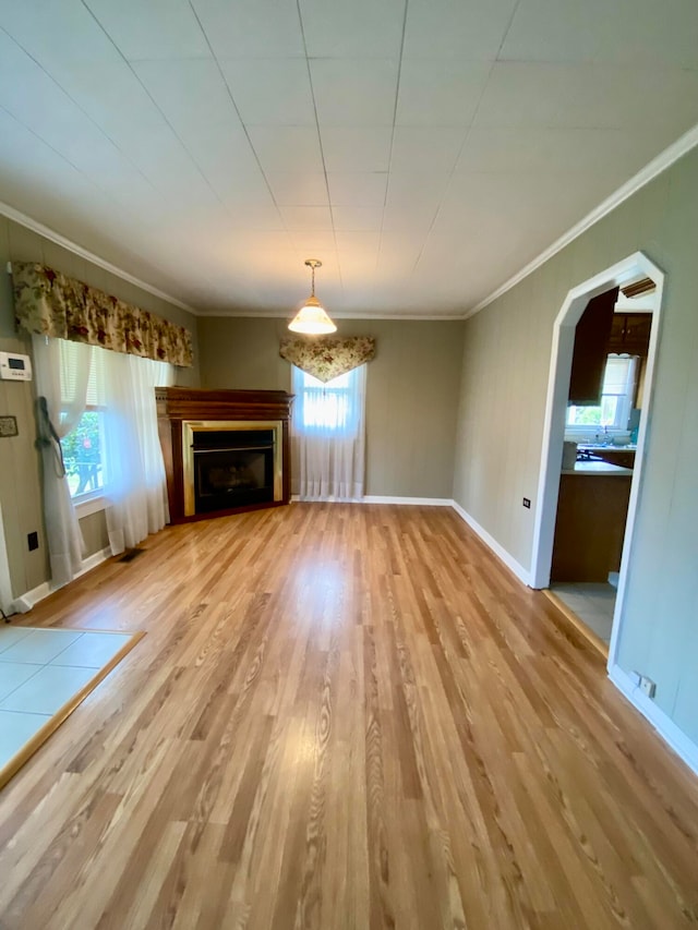 unfurnished living room with crown molding and wood-type flooring