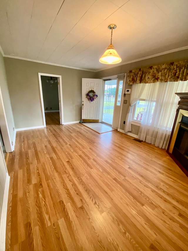 unfurnished living room with light wood-type flooring and crown molding