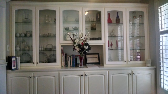 bar featuring a healthy amount of sunlight and white cabinets