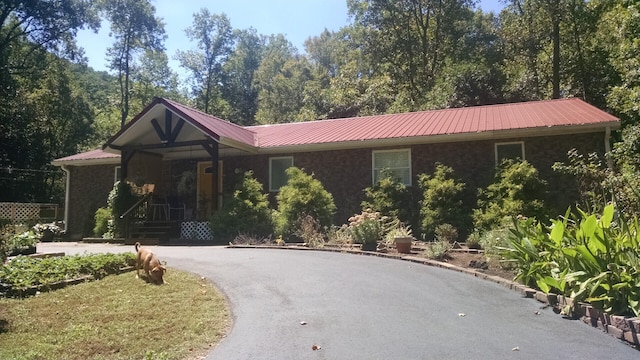 ranch-style house featuring a porch and a front yard