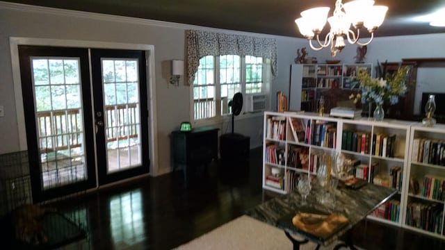 interior space featuring french doors, ornamental molding, and a chandelier