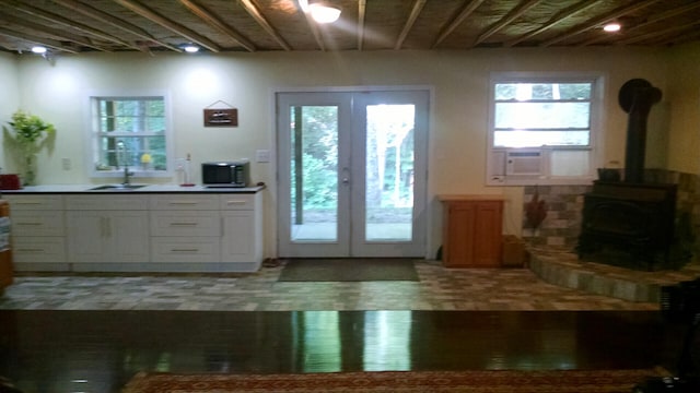 entryway featuring french doors, cooling unit, and a wood stove