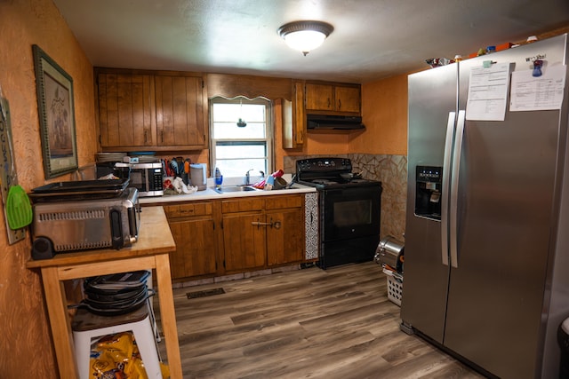 kitchen with dark wood-type flooring, stainless steel appliances, and sink