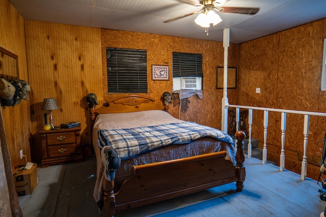 bedroom with ceiling fan, wooden walls, and carpet