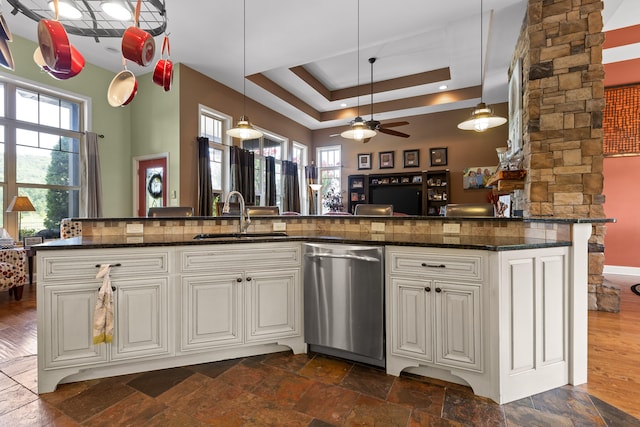 kitchen with ceiling fan, dishwasher, dark stone counters, and sink