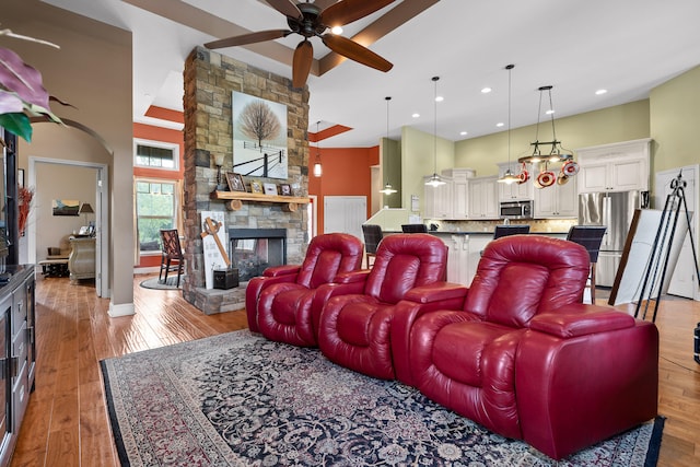 living room featuring light hardwood / wood-style floors, a fireplace, and ceiling fan