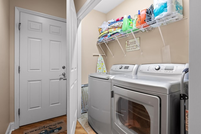 clothes washing area with light hardwood / wood-style floors and independent washer and dryer