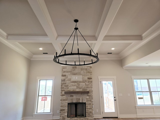 unfurnished living room with beamed ceiling, a healthy amount of sunlight, and coffered ceiling