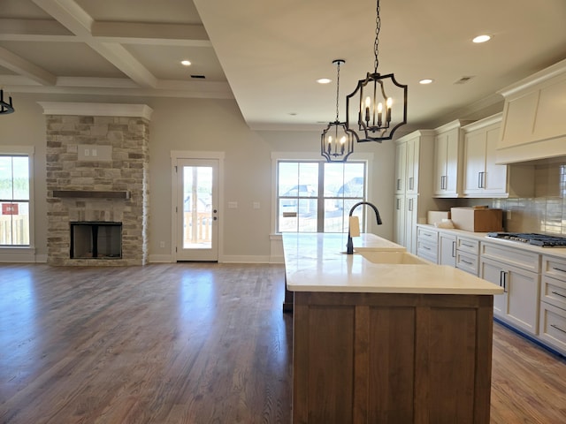 kitchen with stainless steel gas cooktop, sink, decorative light fixtures, plenty of natural light, and a kitchen island with sink