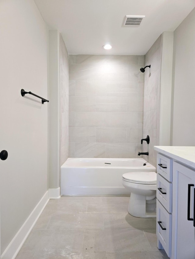 full bathroom featuring tiled shower / bath, vanity, and toilet