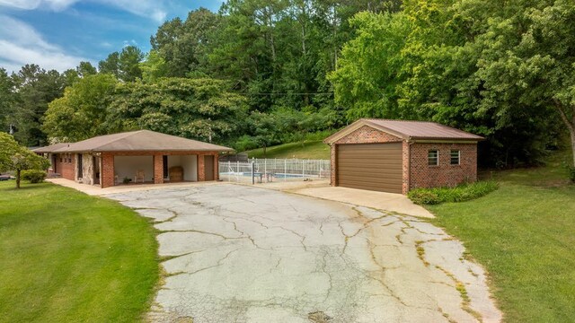 view of front of home featuring an outbuilding, a garage, and a front lawn