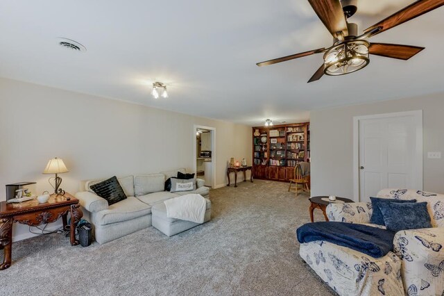 carpeted living room with ceiling fan