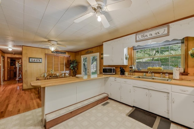 kitchen featuring stainless steel microwave, light floors, visible vents, and light countertops