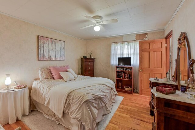 bedroom featuring crown molding, ceiling fan, and light hardwood / wood-style floors