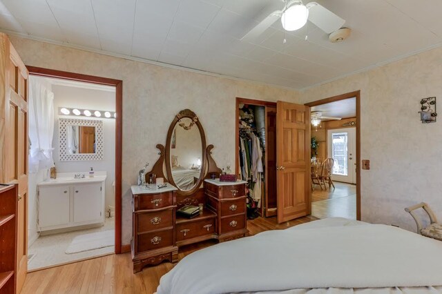 bedroom with ensuite bathroom, light wood-type flooring, sink, a closet, and ceiling fan