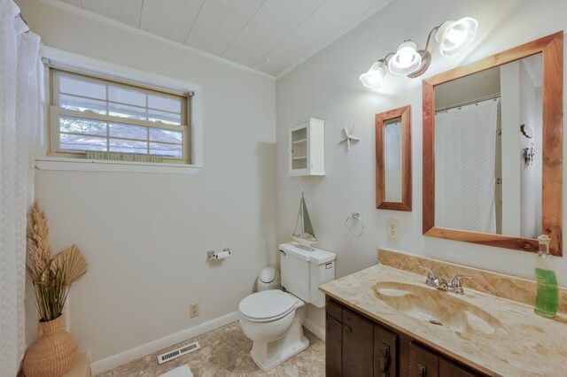 bathroom featuring vanity, toilet, and ornamental molding