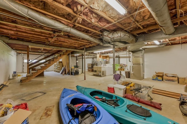 unfinished below grade area featuring stairway and separate washer and dryer