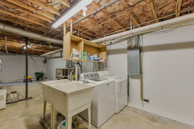 laundry room featuring washing machine and clothes dryer, sink, and electric panel