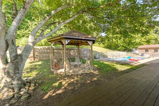 wooden deck with a fenced in pool and a gazebo