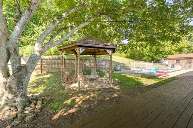 deck featuring a gazebo, a fenced in pool, and a fenced backyard