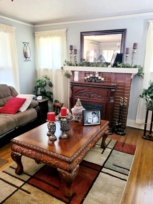 living room featuring ornamental molding, a wealth of natural light, light wood-type flooring, and a fireplace